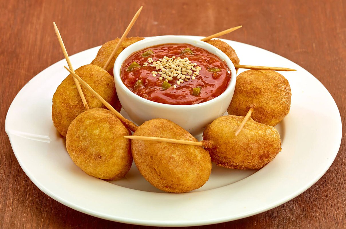 Mini corn dogs with ketchup and jalapeño