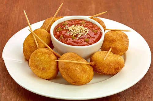 Mini corn dogs with ketchup and jalapeno
