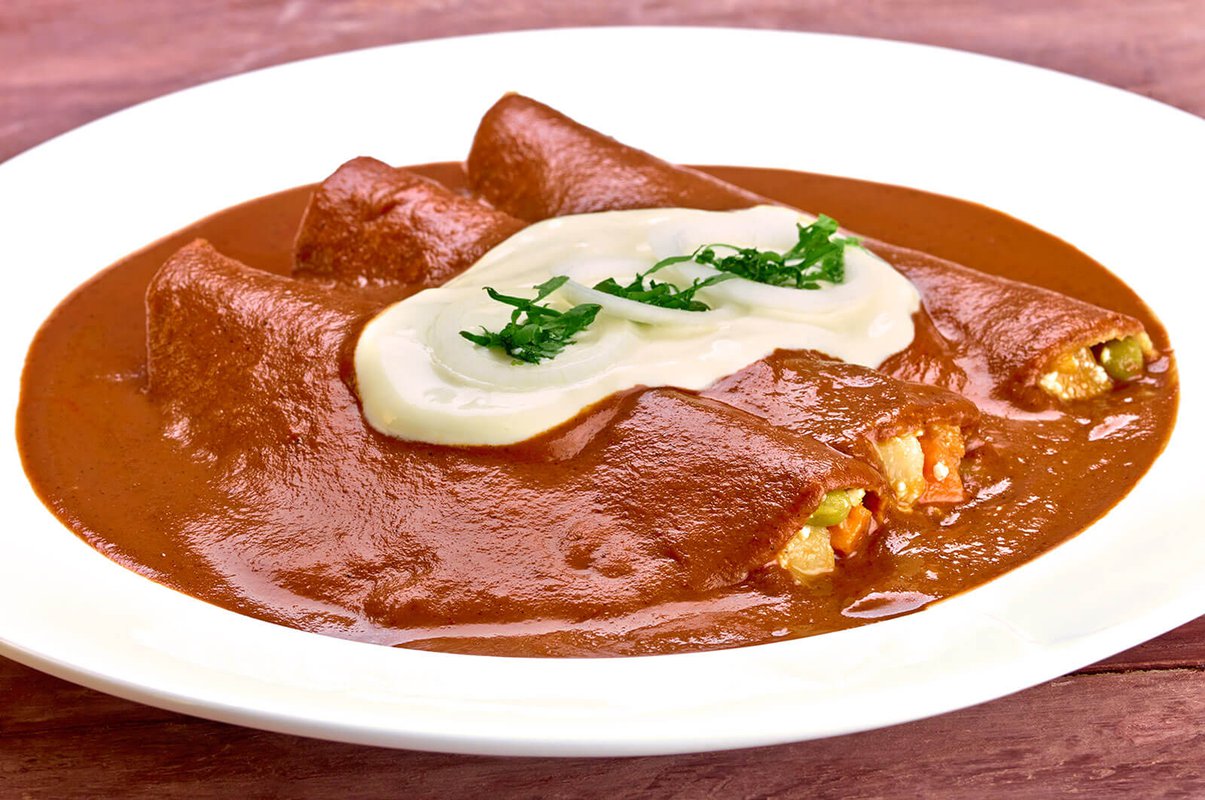 Mole enchiladas filled with añejo cheese